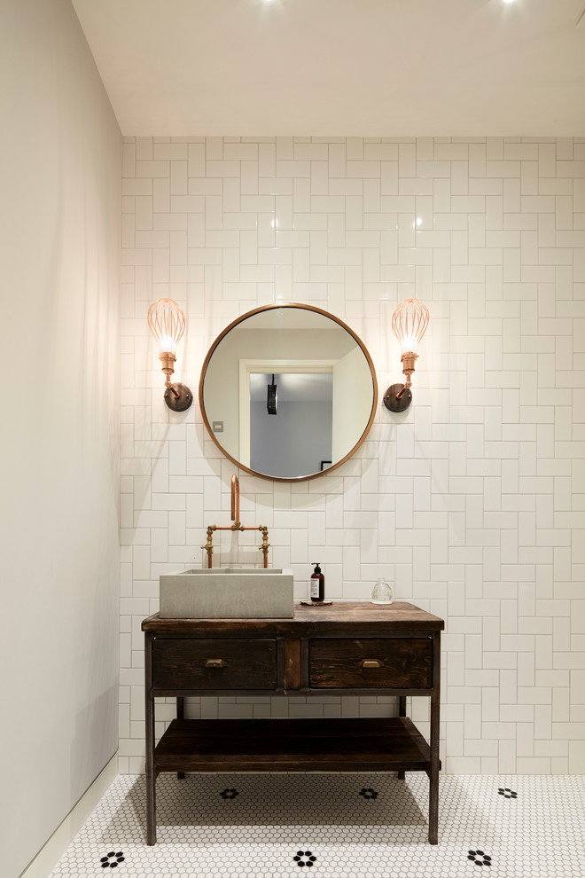 This is an example of a contemporary bathroom in London with a freestanding bath, a built-in shower, beige tiles, white walls and a vessel sink.