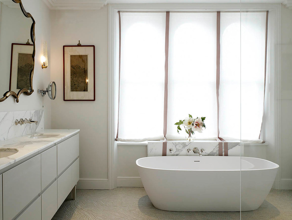 Diseño de cuarto de baño principal actual con lavabo bajoencimera, armarios con paneles lisos, bañera exenta, paredes blancas y suelo con mosaicos de baldosas