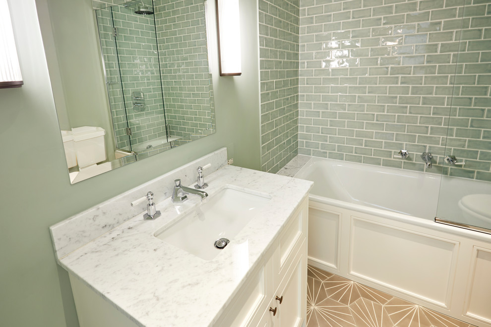 Exempel på ett mellanstort modernt vit vitt en-suite badrum, med skåp i shakerstil, vita skåp, ett platsbyggt badkar, en dusch/badkar-kombination, en vägghängd toalettstol, grön kakel, tunnelbanekakel, gröna väggar, klinkergolv i keramik, ett undermonterad handfat, marmorbänkskiva, brunt golv och dusch med gångjärnsdörr