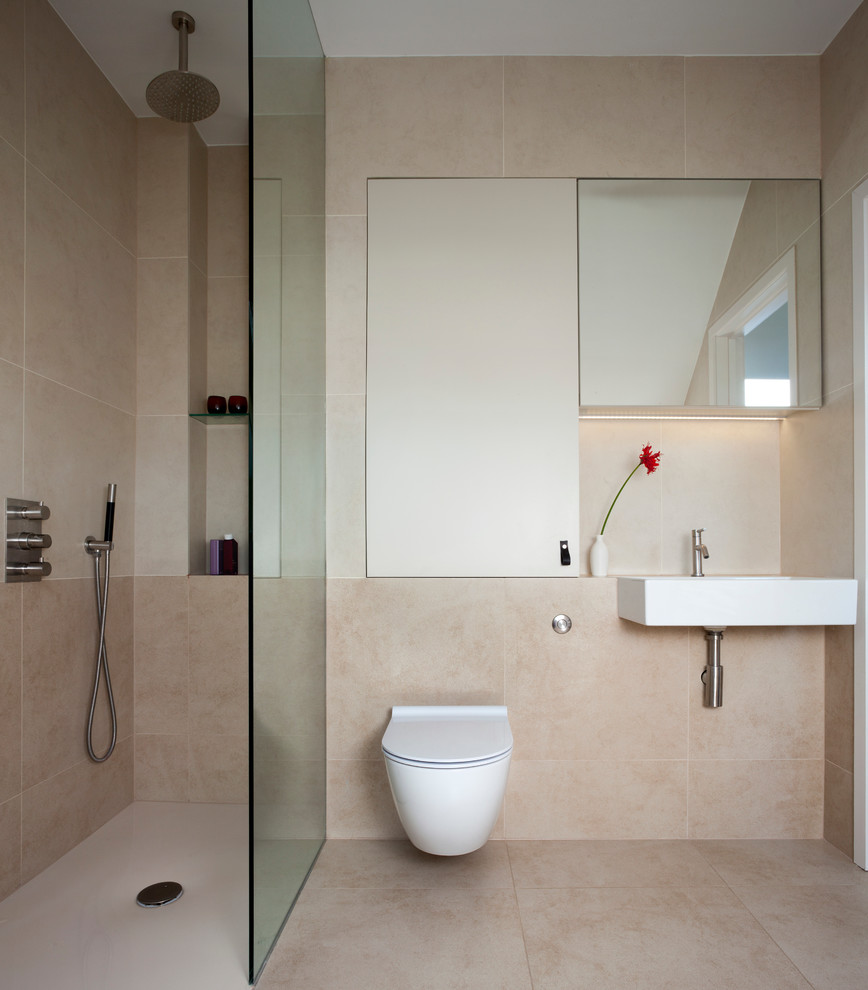 Doorless shower - mid-sized contemporary master beige tile and porcelain tile porcelain tile doorless shower idea in London with flat-panel cabinets, white cabinets, a wall-mount toilet, beige walls and a wall-mount sink