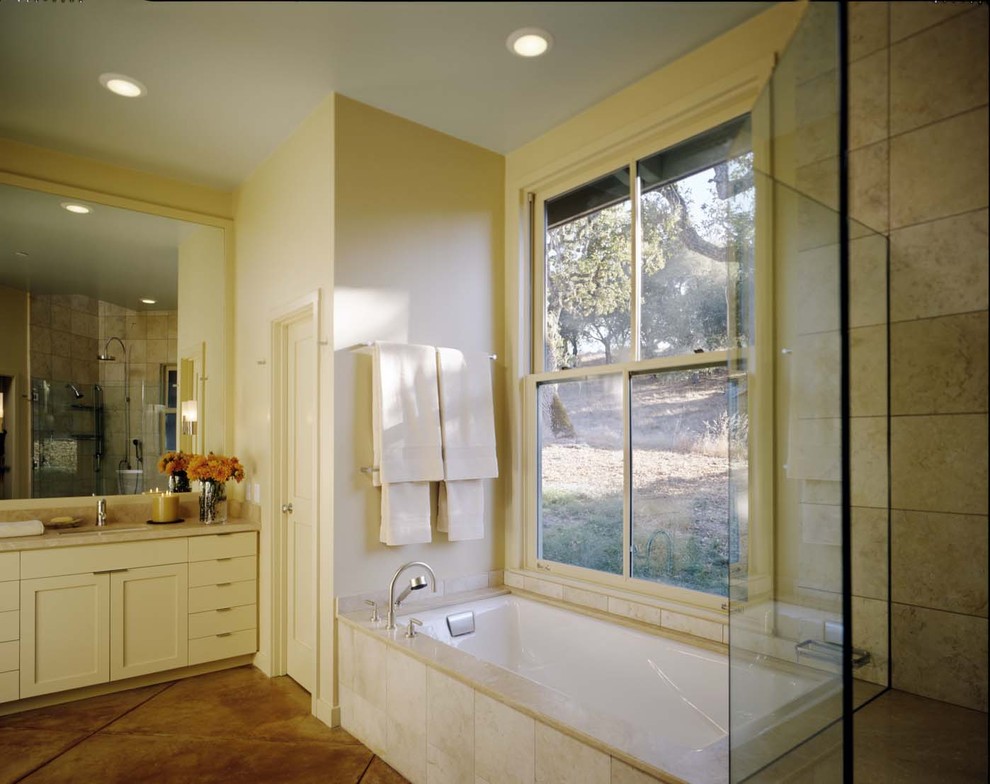 Foto di una stanza da bagno contemporanea con top in pietra calcarea e vasca sottopiano