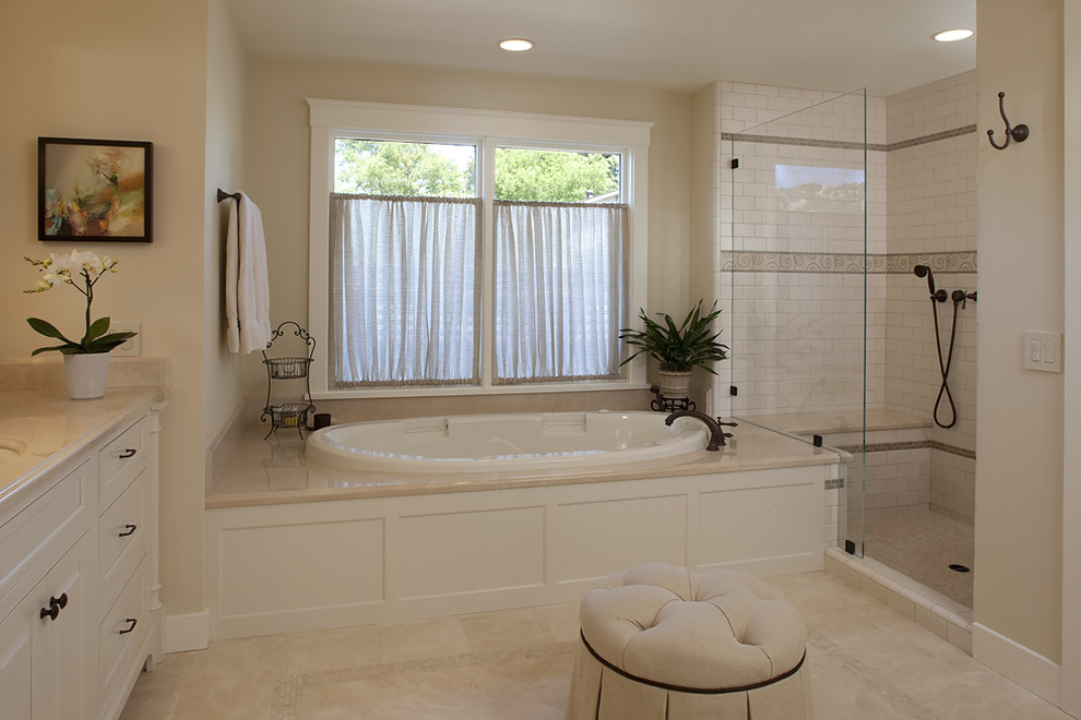 На фото: ванная комната в классическом стиле с врезной раковиной, фасадами с выступающей филенкой, белыми фасадами, накладной ванной, душем в нише, белой плиткой, плиткой кабанчик и бежевой столешницей