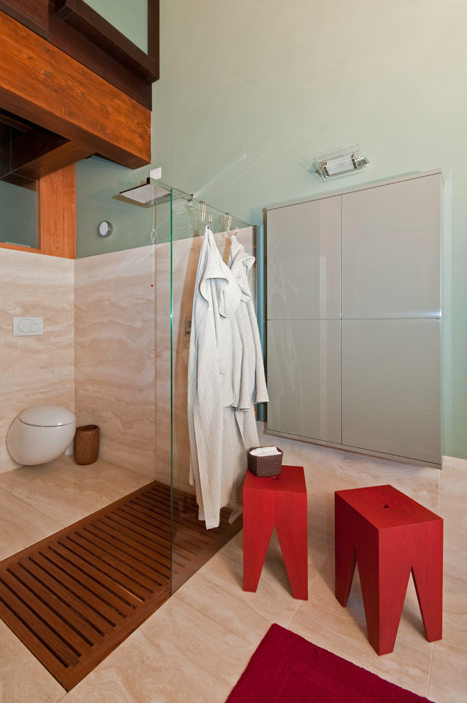Foto de cuarto de baño actual con ducha a ras de suelo, sanitario de pared, losas de piedra, paredes verdes, suelo de mármol y aseo y ducha