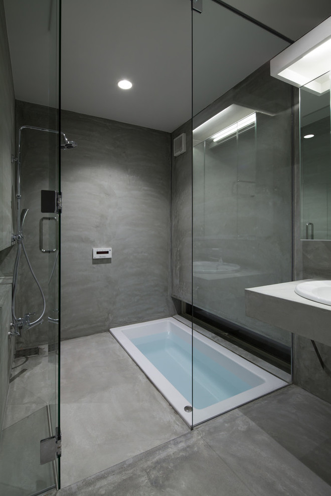 Foto de cuarto de baño contemporáneo con bañera encastrada, ducha a ras de suelo, paredes grises, lavabo encastrado y suelo gris