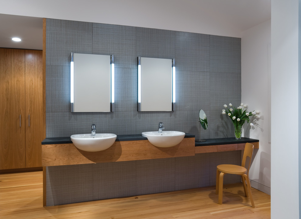 Inspiration for a medium sized modern ensuite bathroom in Dallas with a built-in sink, flat-panel cabinets, medium wood cabinets, a freestanding bath, a walk-in shower, a one-piece toilet, grey tiles, porcelain tiles, white walls and porcelain flooring.