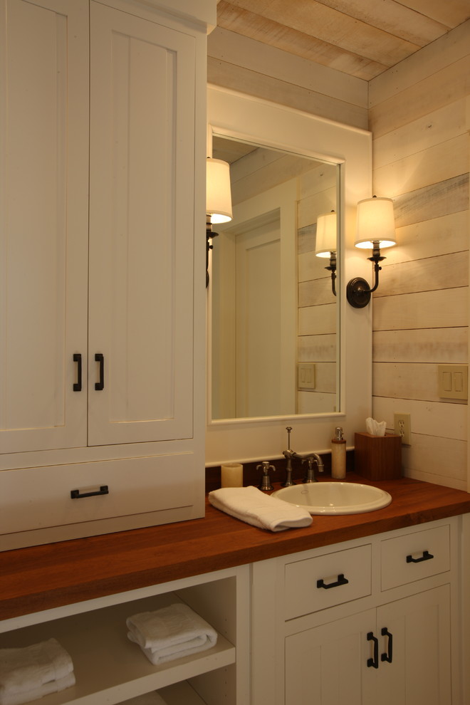 Diseño de cuarto de baño romántico pequeño con puertas de armario blancas, paredes beige, aseo y ducha, lavabo encastrado, encimera de madera y armarios con paneles empotrados