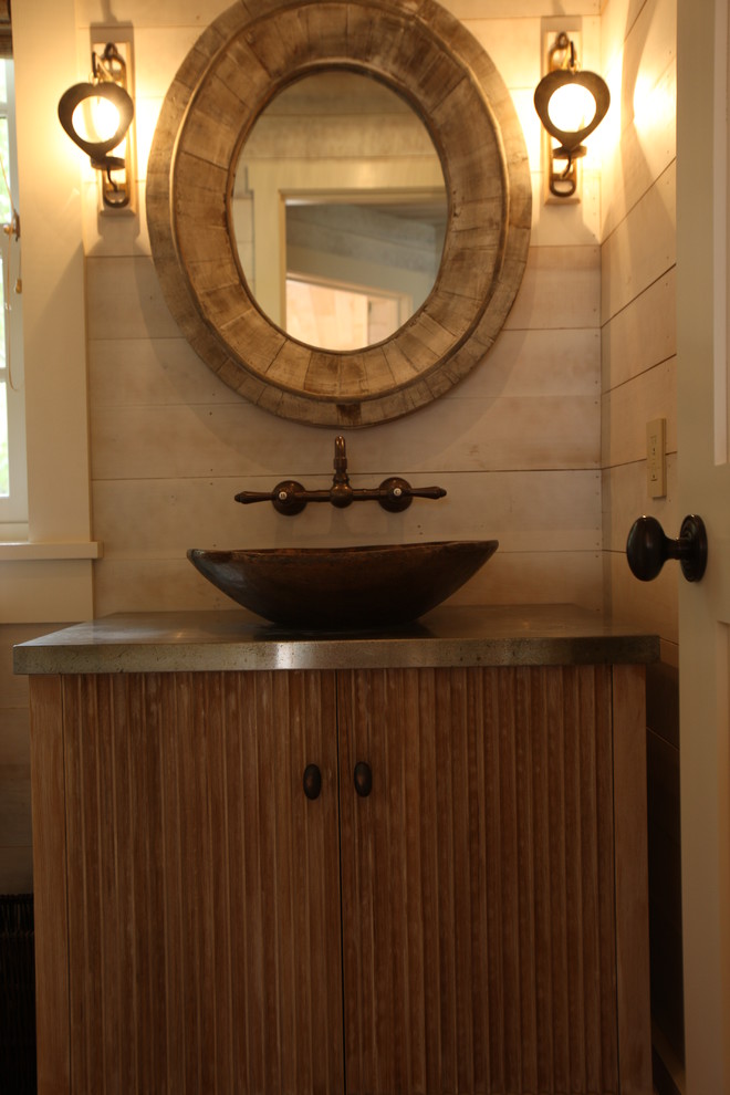 Modelo de cuarto de baño de estilo de casa de campo pequeño con puertas de armario de madera oscura, paredes beige, aseo y ducha, lavabo sobreencimera y encimera de acero inoxidable