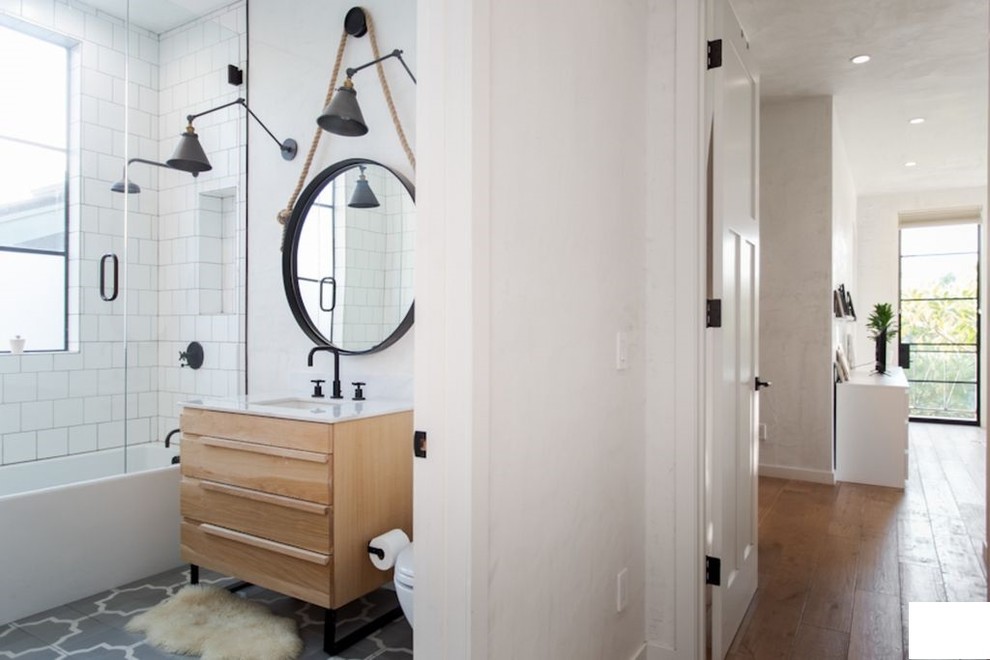 Small eclectic master white tile and ceramic tile ceramic tile and multicolored floor bathroom photo in Los Angeles with beaded inset cabinets, medium tone wood cabinets, a one-piece toilet, white walls, an undermount sink, marble countertops, a hinged shower door and white countertops