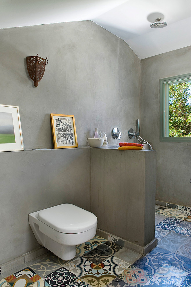 Imagen de cuarto de baño bohemio con ducha abierta, sanitario de pared y ducha abierta
