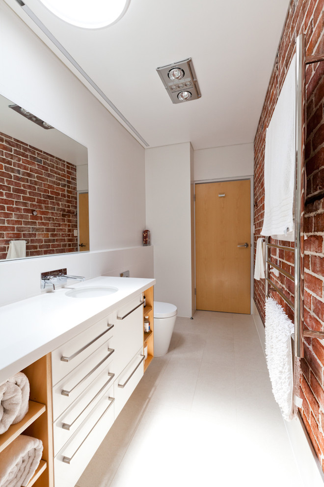 Exempel på ett modernt vit vitt badrum, med ett undermonterad handfat, släta luckor, vita skåp och vita väggar