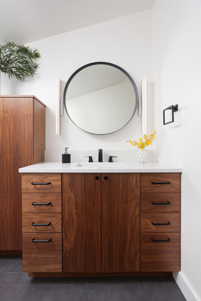 This is an example of a small contemporary ensuite bathroom in Portland with flat-panel cabinets, medium wood cabinets, porcelain tiles, porcelain flooring, a submerged sink, engineered stone worktops, grey floors, white worktops and white walls.