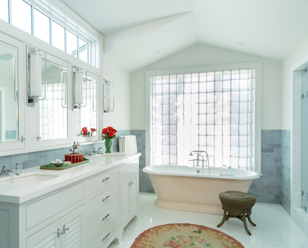 Maritim inredning av ett stort vit vitt en-suite badrum, med luckor med lamellpanel, vita skåp, ett fristående badkar, en dusch i en alkov, blå kakel, marmorkakel, blå väggar, marmorgolv, ett undermonterad handfat, marmorbänkskiva, vitt golv och dusch med gångjärnsdörr