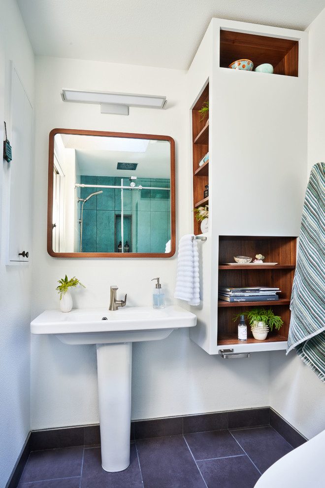 Modern inredning av ett litet en-suite badrum, med öppna hyllor, en dusch i en alkov, grön kakel, porslinskakel, vita väggar, klinkergolv i porslin, ett piedestal handfat, dusch med skjutdörr, vita skåp och grått golv
