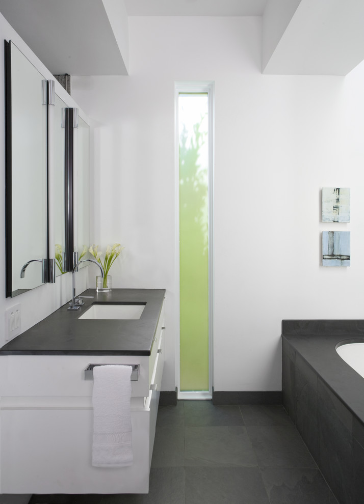 This is an example of a medium sized classic ensuite bathroom in DC Metro with flat-panel cabinets, white cabinets, a submerged bath, black tiles, soapstone worktops, white walls, ceramic flooring, a walk-in shower, grey floors, an open shower and grey worktops.