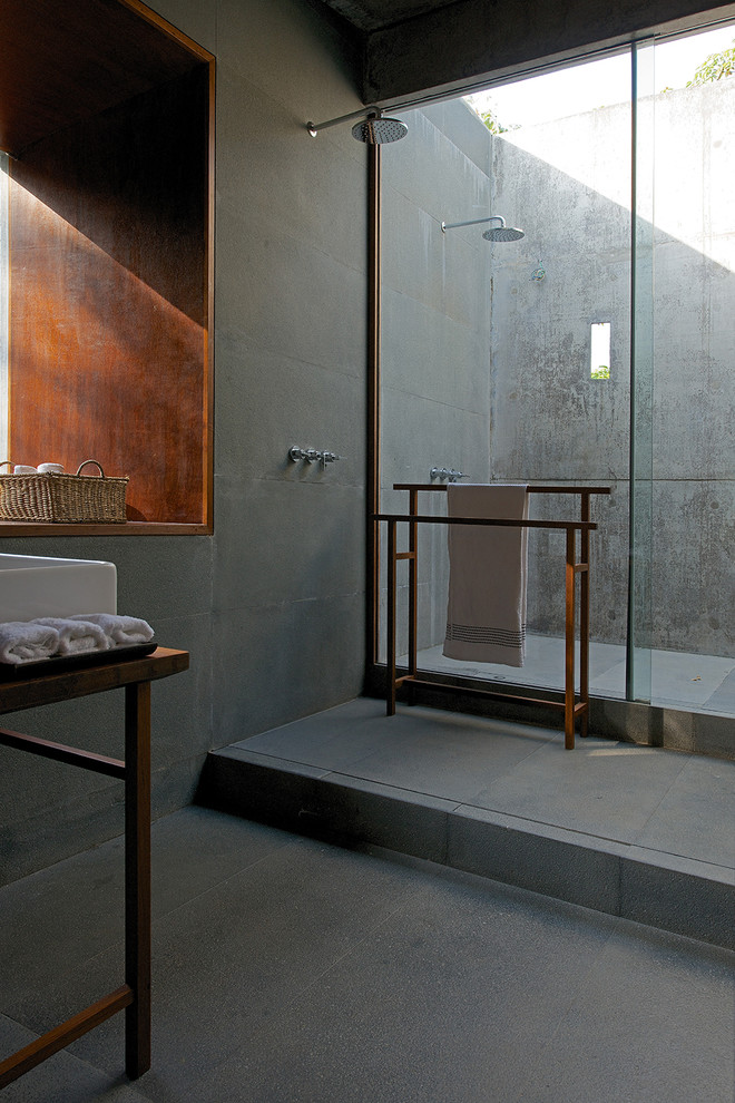 Inspiration för små moderna badrum, med öppna hyllor, skåp i mellenmörkt trä, träbänkskiva, en öppen dusch, grå kakel, cementkakel, grå väggar och med dusch som är öppen