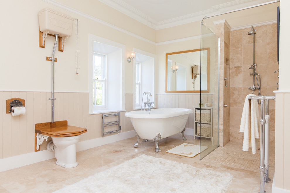 На фото: ванная комната среднего размера в стиле кантри с ванной на ножках, открытым душем, раздельным унитазом, открытым душем, бежевой плиткой, бежевыми стенами и бежевым полом