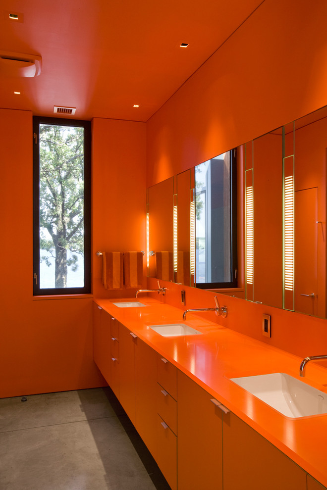 Стильный дизайн: ванная комната в стиле модернизм с врезной раковиной, плоскими фасадами, оранжевыми фасадами, оранжевыми стенами, оранжевой столешницей и окном - последний тренд