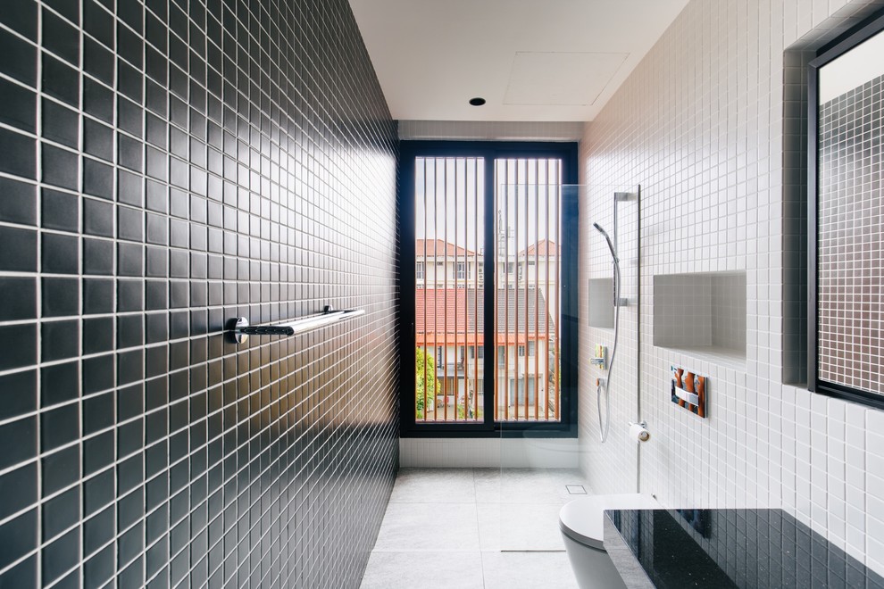 Inspiration för moderna svart badrum, med en kantlös dusch, en vägghängd toalettstol, svart kakel, vit kakel, mosaik, svarta väggar, grått golv och med dusch som är öppen