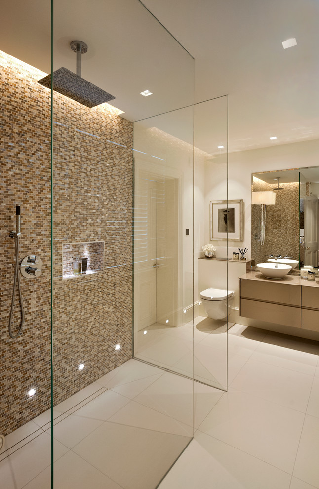 Example of a large trendy master beige tile and mosaic tile porcelain tile doorless shower design in Surrey with a vessel sink, furniture-like cabinets and a wall-mount toilet