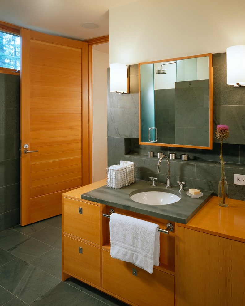 Idéer för att renovera ett mellanstort funkis en-suite badrum, med ett undermonterad handfat, bänkskiva i täljsten, släta luckor, skåp i mellenmörkt trä, en hörndusch, en vägghängd toalettstol, grå kakel, stenkakel, grå väggar och skiffergolv
