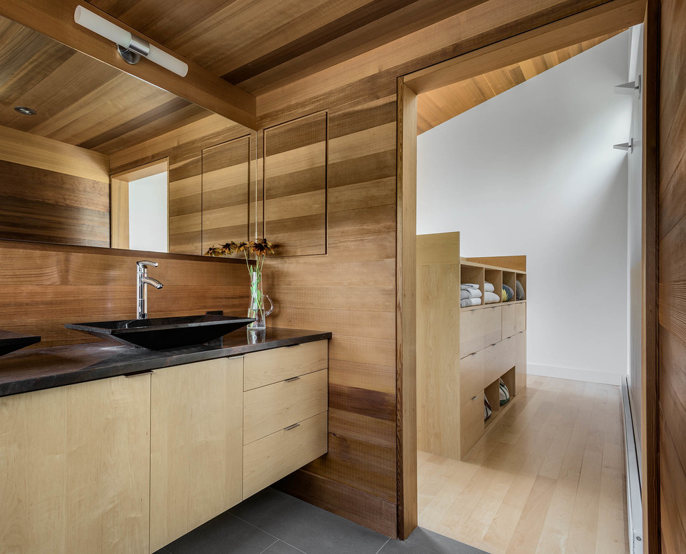 Modernes Badezimmer mit flächenbündigen Schrankfronten, hellen Holzschränken und Aufsatzwaschbecken in Sonstige