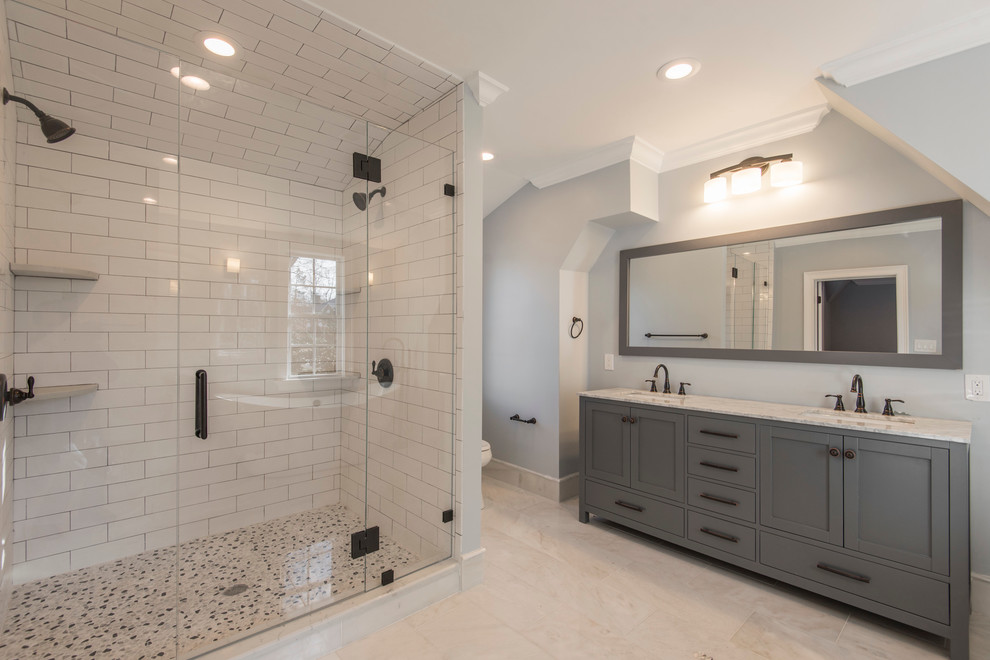 Пример оригинального дизайна: главная ванная комната среднего размера в классическом стиле с фасадами в стиле шейкер, серыми фасадами, отдельно стоящей ванной, душем в нише, белой плиткой, плиткой кабанчик, серыми стенами, полом из известняка, врезной раковиной, столешницей из искусственного кварца, бежевым полом и душем с распашными дверями