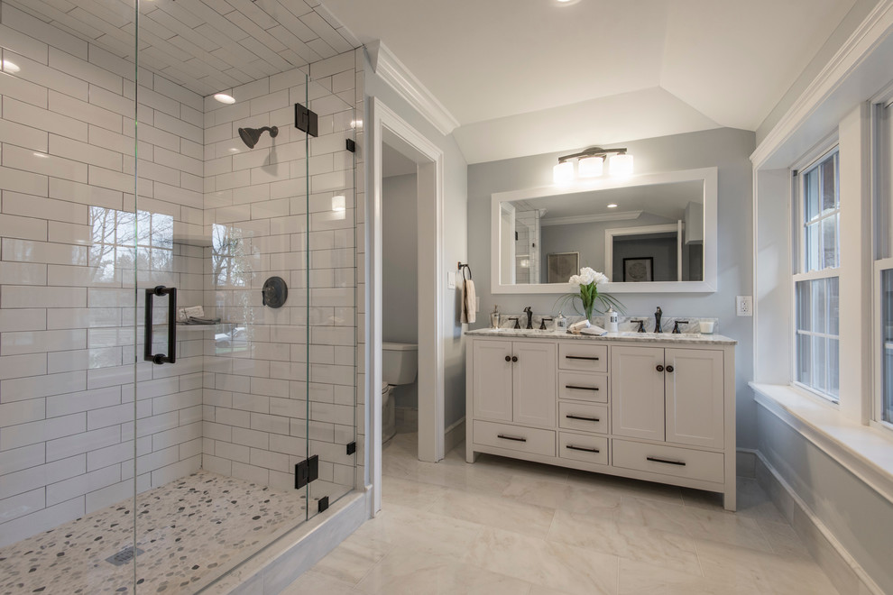 Mid-sized elegant master white tile and subway tile marble floor and beige floor alcove shower photo in Philadelphia with shaker cabinets, white cabinets, a two-piece toilet, blue walls, an undermount sink, quartz countertops and a hinged shower door