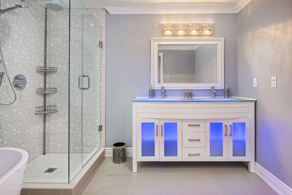トロントにある高級な中くらいなトラディショナルスタイルのおしゃれなバスルーム (浴槽なし) (フラットパネル扉のキャビネット、白いキャビネット、置き型浴槽、コーナー設置型シャワー、分離型トイレ、グレーのタイル、磁器タイル、グレーの壁、磁器タイルの床、一体型シンク、ガラスの洗面台、グレーの床、開き戸のシャワー) の写真