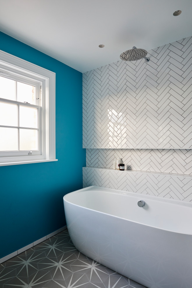 Example of a large eclectic kids' white tile and porcelain tile porcelain tile and gray floor bathroom design in London with flat-panel cabinets, black cabinets, a wall-mount toilet, blue walls, an integrated sink and white countertops