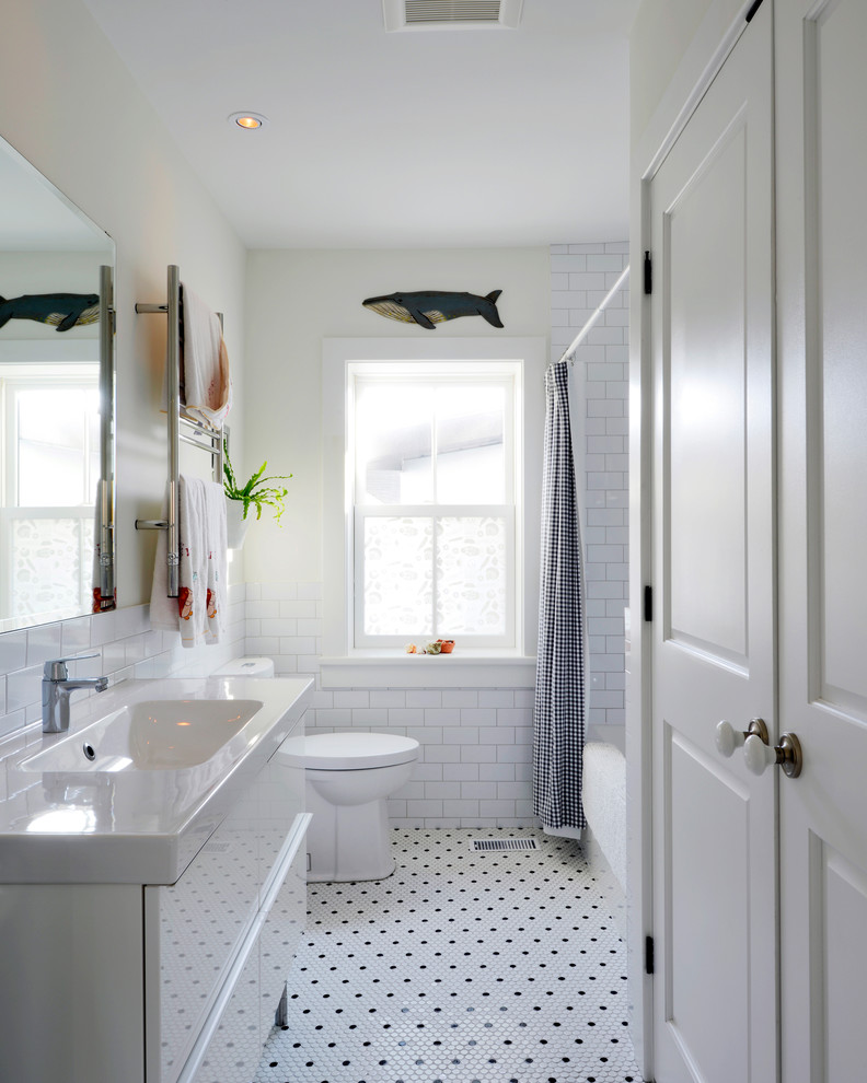 Cette image montre une salle de bain traditionnelle avec un lavabo intégré, des portes de placard blanches, une baignoire en alcôve, un combiné douche/baignoire, un carrelage blanc, un carrelage métro, un mur blanc, un sol en carrelage de terre cuite et une cabine de douche avec un rideau.