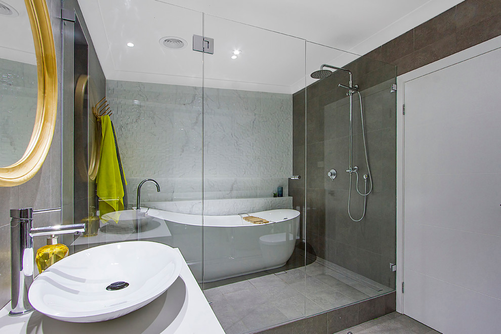 Пример оригинального дизайна: большая главная ванная комната в стиле модернизм с плоскими фасадами, белыми фасадами, отдельно стоящей ванной, двойным душем, унитазом-моноблоком, черно-белой плиткой, керамогранитной плиткой, черными стенами, полом из керамогранита, подвесной раковиной и столешницей из искусственного камня