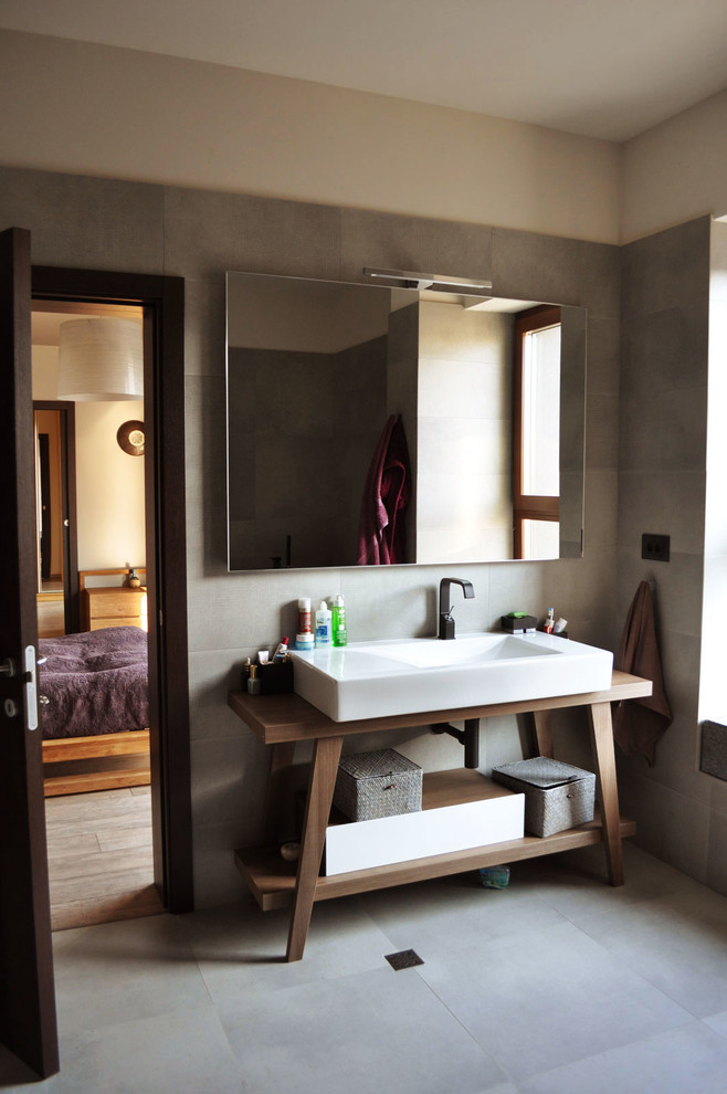 Aménagement d'une salle de bain principale éclectique de taille moyenne avec une baignoire indépendante, une douche ouverte, WC suspendus, un carrelage gris, des carreaux de céramique, un mur gris et un sol en carrelage de céramique.