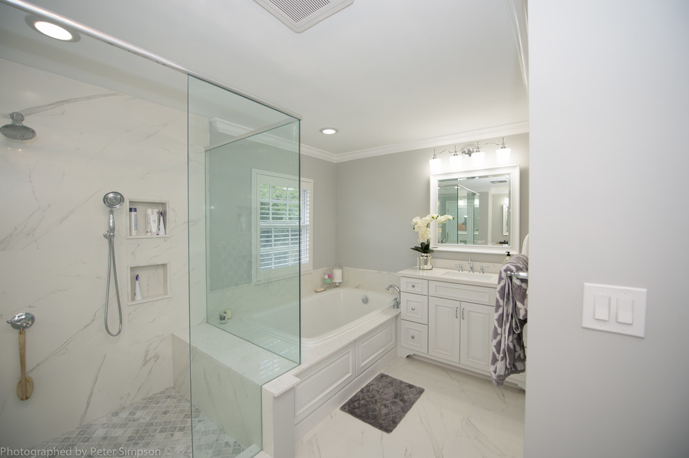 Идея дизайна: большая главная ванная комната в стиле неоклассика (современная классика) с фасадами островного типа, белыми фасадами, накладной ванной, двойным душем, раздельным унитазом, белой плиткой, мраморной плиткой, серыми стенами, мраморным полом, врезной раковиной, мраморной столешницей, белым полом и душем с распашными дверями