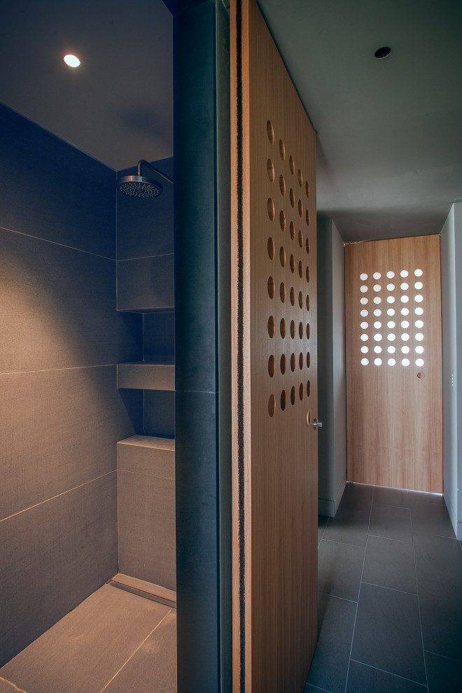 Bild på ett stort funkis en-suite badrum, med grå kakel, grå väggar, grå skåp, en hörndusch, stenhäll, klinkergolv i porslin, grått golv och med dusch som är öppen