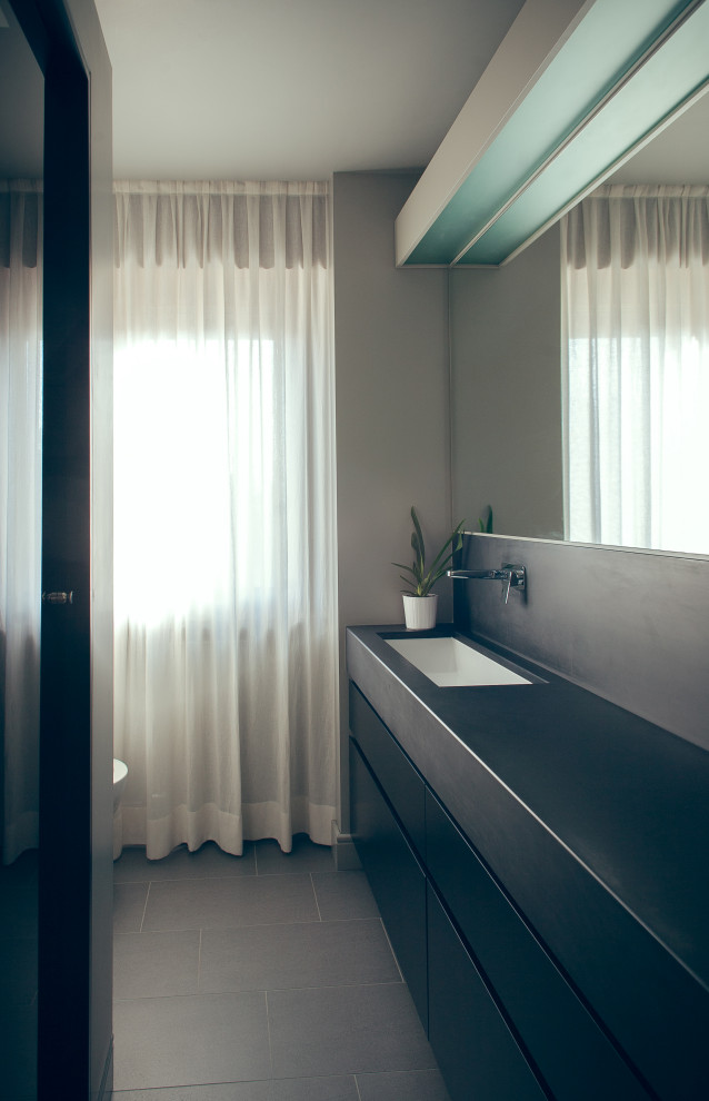 Idéer för ett litet modernt en-suite badrum, med ett väggmonterat handfat, svarta skåp, marmorbänkskiva, en hörndusch, en toalettstol med separat cisternkåpa, svart kakel, stenkakel, grå väggar, klinkergolv i keramik och släta luckor