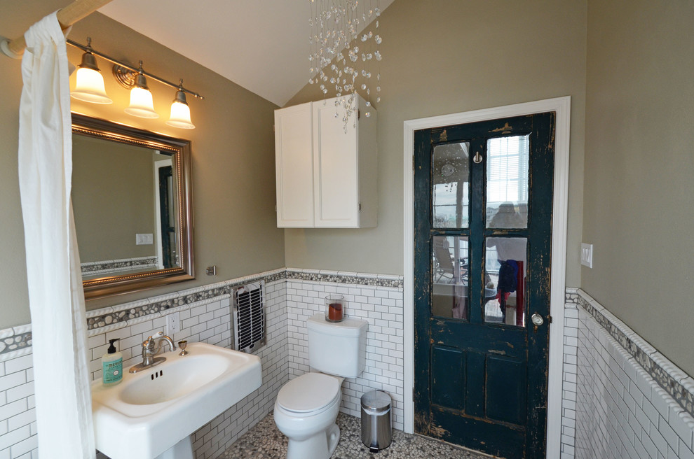 Cette photo montre une salle de bain principale éclectique de taille moyenne avec une baignoire sur pieds, un carrelage métro, un mur vert, un sol en galet, WC séparés et un lavabo de ferme.