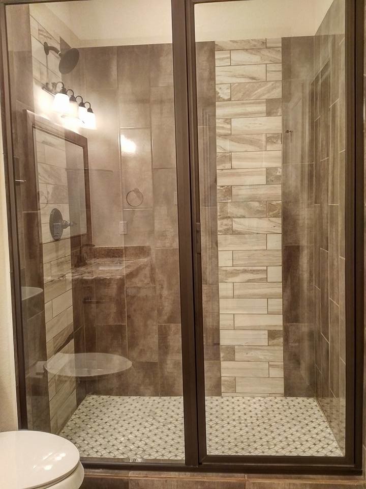Modern inredning av ett mellanstort badrum med dusch, med luckor med upphöjd panel, bruna skåp, en öppen dusch, en toalettstol med hel cisternkåpa, beige kakel, marmorkakel, beige väggar, klinkergolv i porslin, ett nedsänkt handfat, granitbänkskiva, grått golv och dusch med gångjärnsdörr