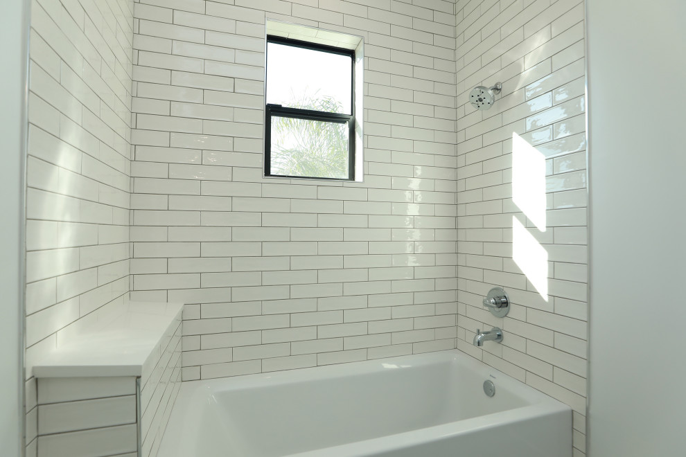 Example of a large country kids' white tile and porcelain tile ceramic tile and gray floor bathroom design in Houston with flat-panel cabinets, black cabinets, a one-piece toilet, white walls, an integrated sink, quartz countertops and white countertops