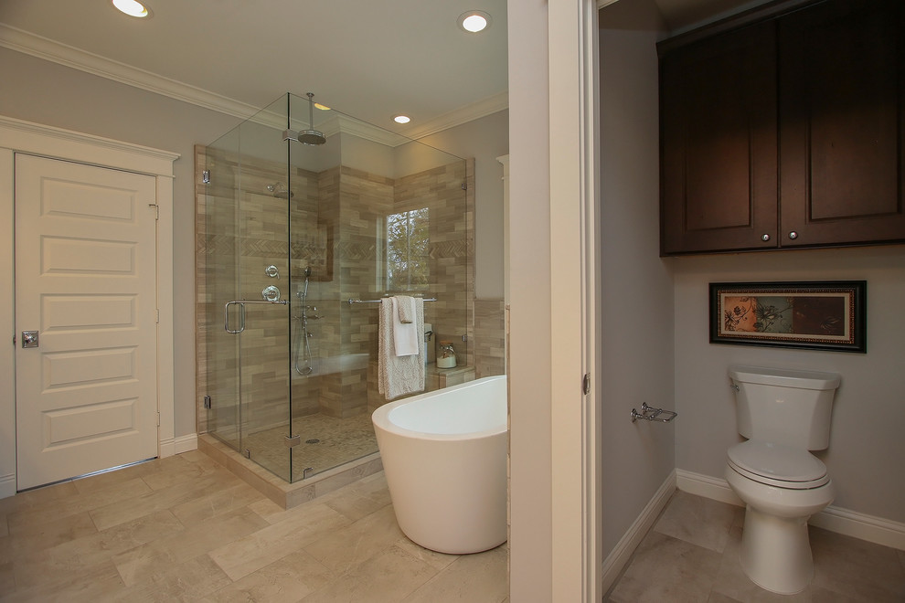 Immagine di una stanza da bagno padronale tradizionale di medie dimensioni con vasca freestanding, doccia ad angolo, WC a due pezzi, piastrelle beige, piastrelle in gres porcellanato e pareti grigie