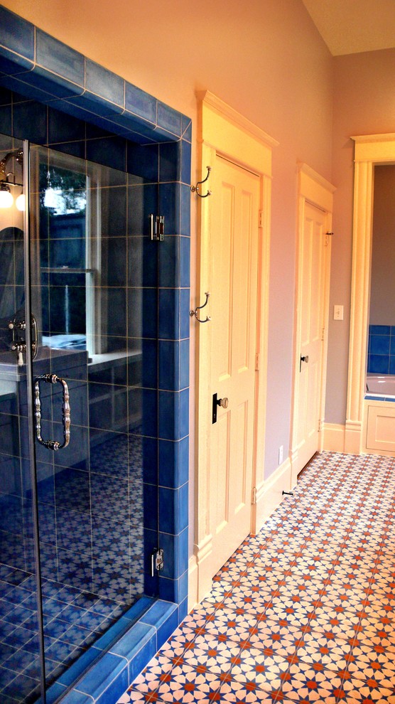 Imagen de cuarto de baño tradicional con armarios estilo shaker, puertas de armario beige, encimera de madera, bañera encastrada, ducha empotrada, sanitario de dos piezas, baldosas y/o azulejos azules y baldosas y/o azulejos de cemento