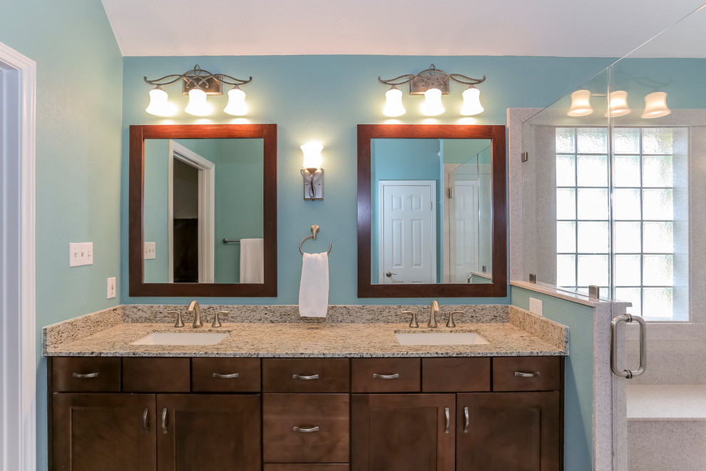 На фото: большая ванная комната в стиле неоклассика (современная классика) с фасадами в стиле шейкер, темными деревянными фасадами, бежевой плиткой, синими стенами, душевой кабиной, врезной раковиной и столешницей из гранита с