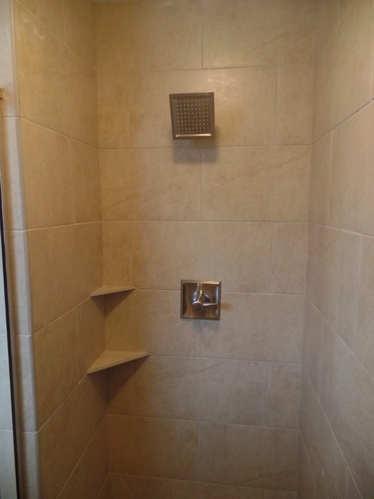 Inredning av ett klassiskt mellanstort badrum med dusch, med ett integrerad handfat, luckor med upphöjd panel, skåp i mellenmörkt trä, bänkskiva i akrylsten, en dusch i en alkov, en toalettstol med separat cisternkåpa, beige kakel, porslinskakel, beige väggar och klinkergolv i porslin