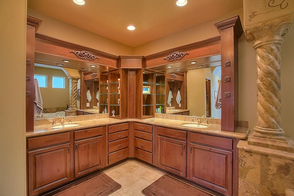 This is an example of a medium sized ensuite bathroom in Albuquerque with raised-panel cabinets, medium wood cabinets, beige tiles, beige walls, limestone flooring, a submerged sink, granite worktops, a built-in bath, stone tiles and a walk-in shower.