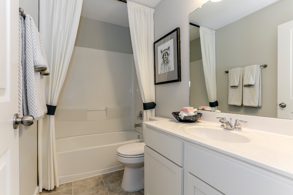 Mid-sized transitional kids' white tile and limestone tile ceramic tile and beige floor bathroom photo in Houston with recessed-panel cabinets, white cabinets, gray walls, an undermount sink and solid surface countertops