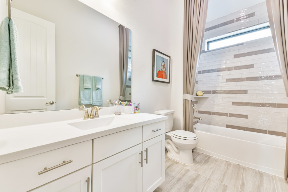 Example of a mid-sized trendy kids' beige tile and ceramic tile ceramic tile, beige floor and single-sink bathroom design in Houston with recessed-panel cabinets, white cabinets, white walls, an undermount sink, solid surface countertops and white countertops