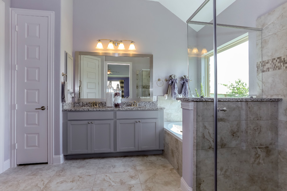 Example of a large master beige tile and ceramic tile ceramic tile and beige floor bathroom design in Houston with recessed-panel cabinets, gray cabinets, purple walls, an undermount sink, granite countertops and a hinged shower door