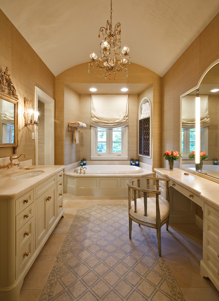 This is an example of a traditional ensuite bathroom in Houston with recessed-panel cabinets, beige cabinets, brown walls, a submerged sink and a built-in bath.