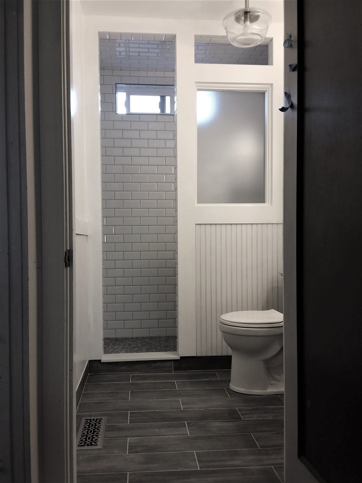 Small contemporary ensuite bathroom with freestanding cabinets, white cabinets, a walk-in shower, a one-piece toilet, white tiles, porcelain tiles, white walls, porcelain flooring, an integrated sink, engineered stone worktops, grey floors, an open shower and white worktops.