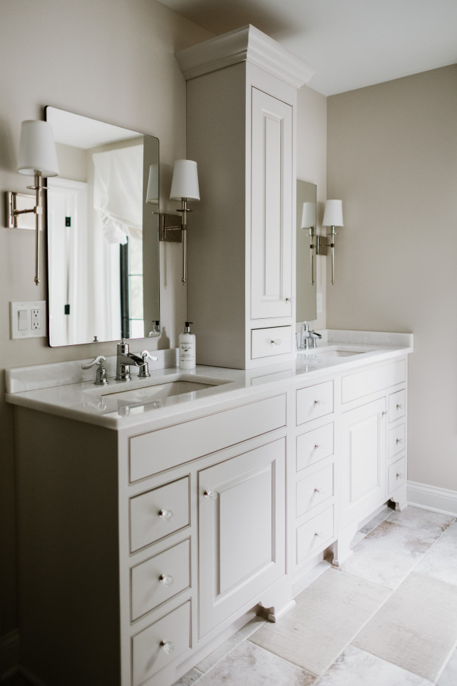 Exemple d'une salle de bain chic avec un placard à porte affleurante, des portes de placard grises, un mur beige, un lavabo encastré, un sol gris, un plan de toilette blanc, meuble double vasque et meuble-lavabo encastré.