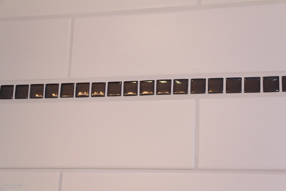 Cette image montre une petite salle de bain principale traditionnelle en bois foncé avec un placard à porte plane, une baignoire d'angle, un combiné douche/baignoire, WC séparés, un carrelage blanc, un carrelage métro, un mur violet, un sol en vinyl, un lavabo intégré et un plan de toilette en surface solide.